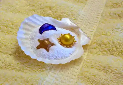 Epsom salt with bath decoratives in a shell placed on a towel